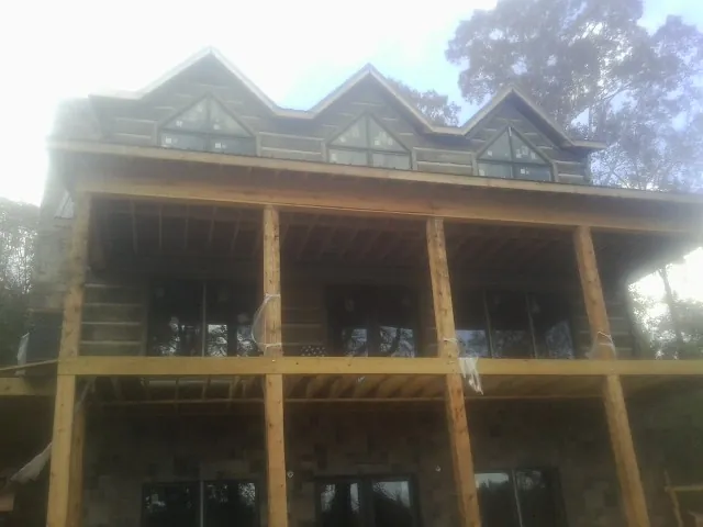 Dormers and porch framing on a large log home under construction — Roof Coating work by our crew in Denver