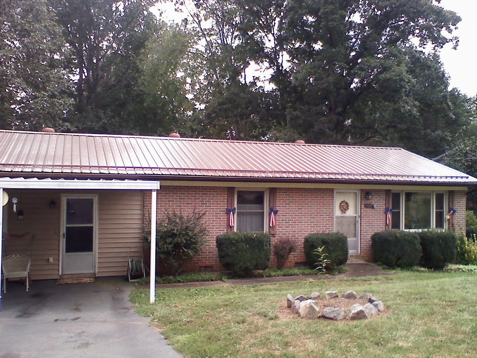 Bronze metal roof and carport on a brick ranch home — Roof Repair work by our crew in Denver